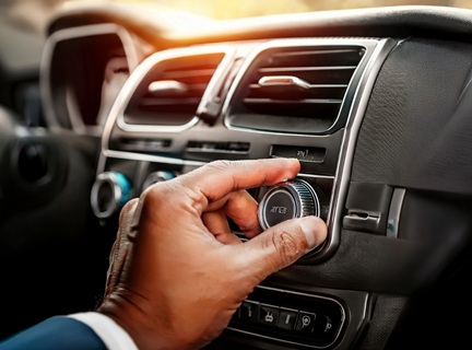 Hand tunes a car radio.